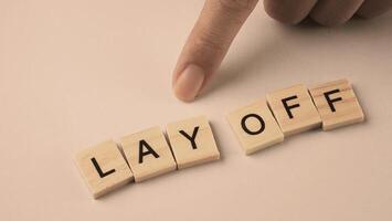 Word of Lay Off. Text written by wood toy or wood cubes on white paper background photo