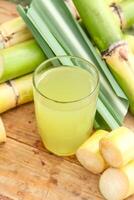 Drink from sugar cane juice, squeezed sugar cane juice with sugar cane stalks and natural background photo