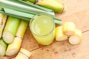 Drink from sugar cane juice, squeezed sugar cane juice with sugar cane stalks and natural background photo
