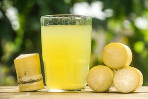 Drink from sugar cane juice, squeezed sugar cane juice with sugar cane stalks and natural background photo