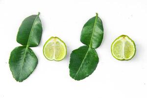 Citrus hystrix or kaffir lime or bergamot sliced fruit and its leaves isolated on white background photo