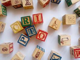 A photo of a wooden block with the words crypto written on it, styled in isolation with space for text.