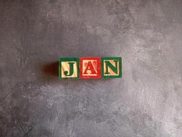 A photo of a wooden block with the words january written on it, styled in isolation with space for text.