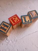 A photo of a wooden block with the words hell written on it, styled in isolation with space for text.