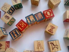 A photo of a wooden block with the words hello written on it, styled in isolation with space for text.