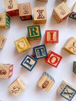 A photo of a wooden block with the words crypto written on it, styled in isolation with space for text.