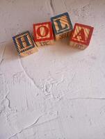 A photo of a wooden block with the words hola written on it, styled in isolation with space for text.