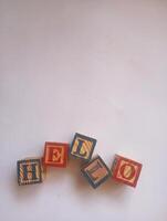 A photo of a wooden block with the words hello written on it, styled in isolation with space for text.