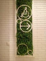A photo of directional signs for accessible restroom for individuals with disabilities