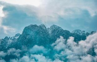 Conquering the clouds, unveiling the majesty of nature's untamed peaks. A journey through the mystical realm of towering mountains. photo