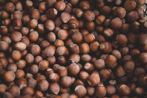 Hazelnuts in a wooden bowl on rustic background, Hazelnut background with green leaf photo