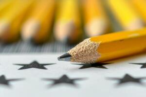 A pencil with a broken tip is on top of a star pattern photo