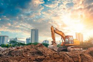 A large yellow construction machine is digging in a dirt field photo