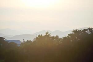 sky ,tree , mountain and house background or a house and tree photo