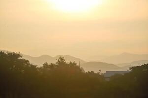 sky ,tree , mountain and house background or a house and tree photo