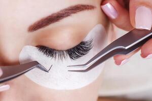 Eyelash Extension Procedure. Woman Eye with Long Eyelashes. Lashes, close up, macro, selective focus. photo