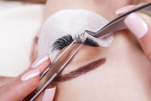 Eyelash Extension Procedure. Woman Eye with Long Eyelashes. Lashes, close up, macro, selective focus. photo