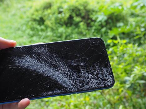 The mobile phone fell on the floor and the screen cracked. photo