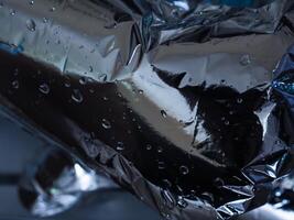 Silver plastic texture in the dark for a mysterious abstract background. photo