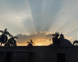 sunbeams shine through the clouds over a building photo
