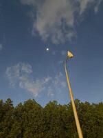 a street light and a moon in the sky photo