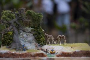 Macro photography of two toy giraffes grazing. Toy photography concept with bokeh background. photo