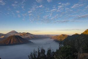 Beautiful wide angle view of Bromo Tengger Semeru National Park, an ecosystem conservation area consisting of mountains and calderas that has a desert area located in East Java, Indonesia. photo
