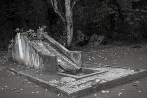 An abandoned and scary slide in a playground near the woods photo