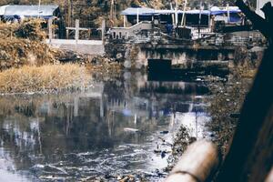A small river that is polluted with waste from garbage and has become pitch black in color. photo