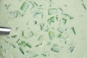 a bowl of green dessert with a spoon in it photo