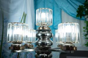 A silver and glass chandelier with four lights photo