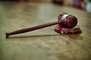 A judge's gavel on a wooden table photo