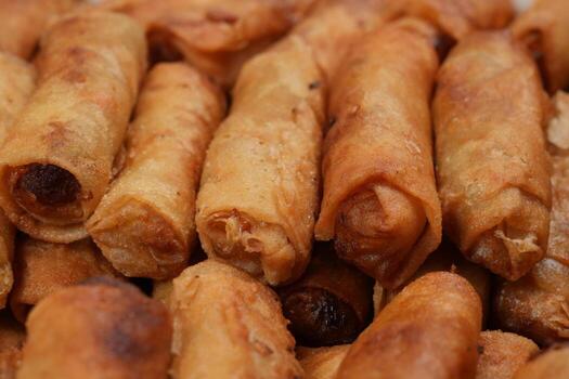 a close up of a pile of fried spring rolls photo