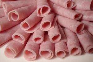 a pile of sliced ham on a white surface photo