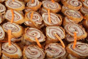 a large pile of rolls with meat and carrots photo