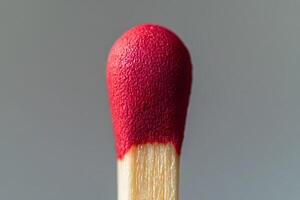 Detailed Close-Up of Matchstick with Red Tip on Neutral Background photo