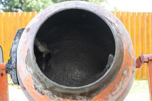 Mixing mortar in a handheld portable concrete mixer photo