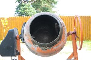 Mixing mortar in a handheld portable concrete mixer photo