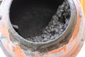 Mixing mortar in a handheld portable concrete mixer photo