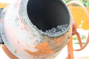Mixing mortar in a handheld portable concrete mixer photo