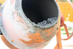 Mixing mortar in a handheld portable concrete mixer photo