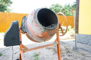 Mixing mortar in a handheld portable concrete mixer photo