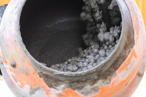 Mixing mortar in a handheld portable concrete mixer photo