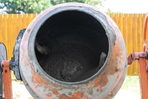 Mixing mortar in a handheld portable concrete mixer photo