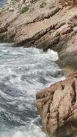 The waves breaking on a stony beach, forming a spray. Footage. Splashing waves on the rocks of the sea video