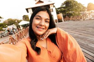 Latin american young using brackets smiling and taking a selfie. photo