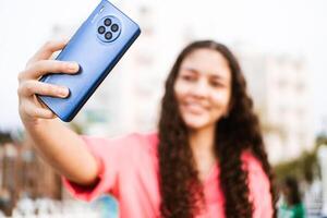 Selective focus of a phone, blurred woman making a with mobile phone. photo