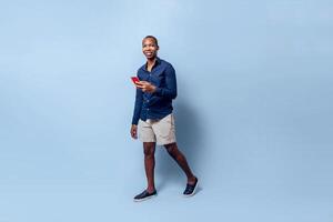 full body of african young man using a mobile phone online app technology concept over a background. photo