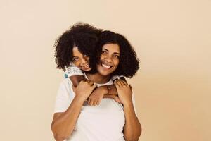 young black mother and little daughter hugging each other looking at camera photo