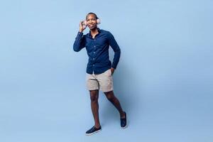Full length of a black african man wearing a headphones looking at camera. photo